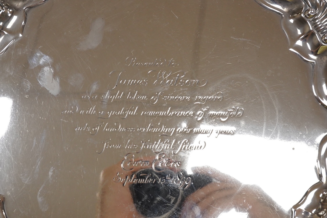 A late Victorian silver salver, with shell and scroll border and engraved inscription, on three claw and ball feet, Mappin Brothers, Sheffield, 1896, 26.4cm, 15.2oz.